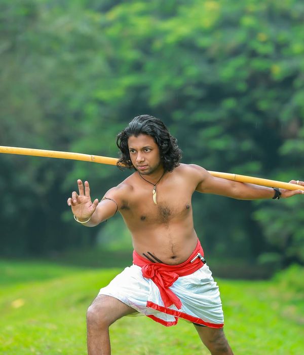 A man performing a bodyweight strength exercise in a dark, focused environment.